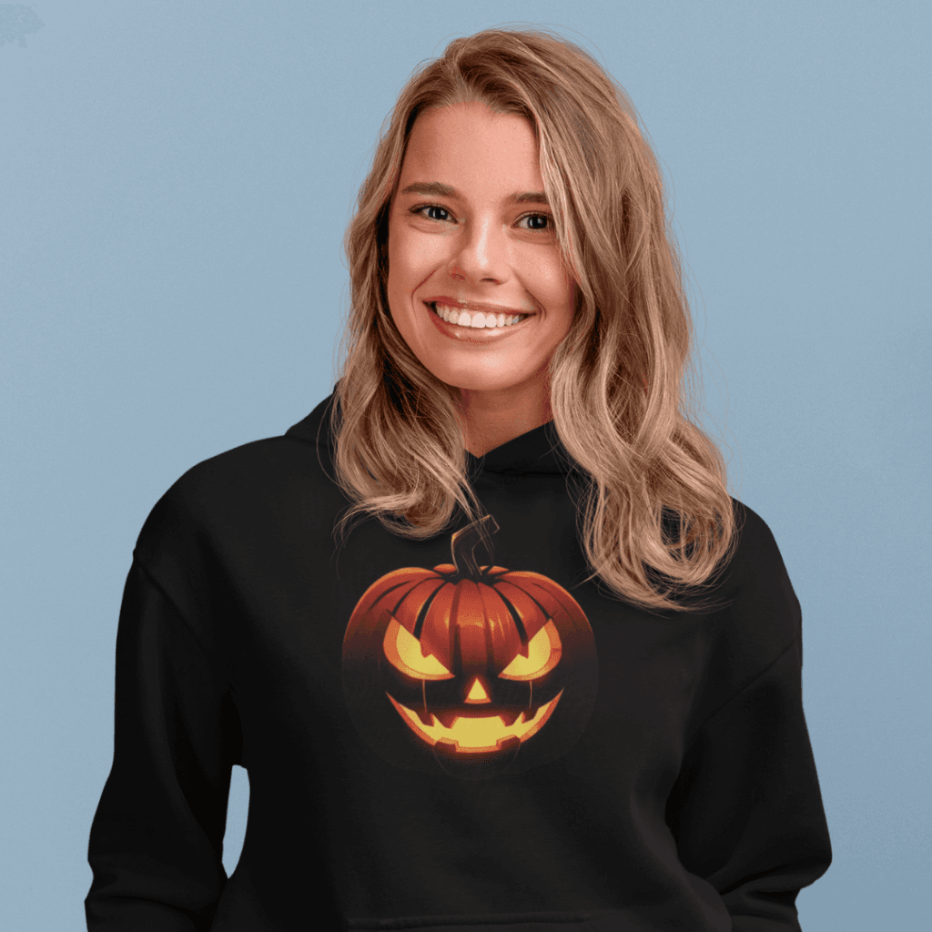 3D jack-o'-lantern face with glowing eyes and menacing grin, appearing to pop out from a dark t-shirt background.